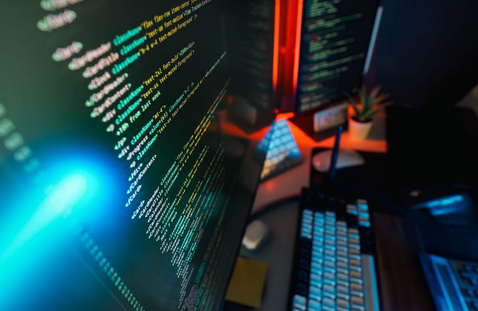 Futuristic workspace featuring a glowing computer screen with coding displayed